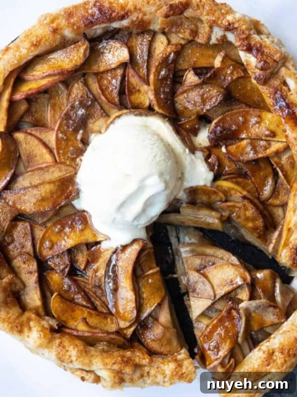 Puff Pastry Apple Tart on a white marble background with a scoop of ice cream in the centre