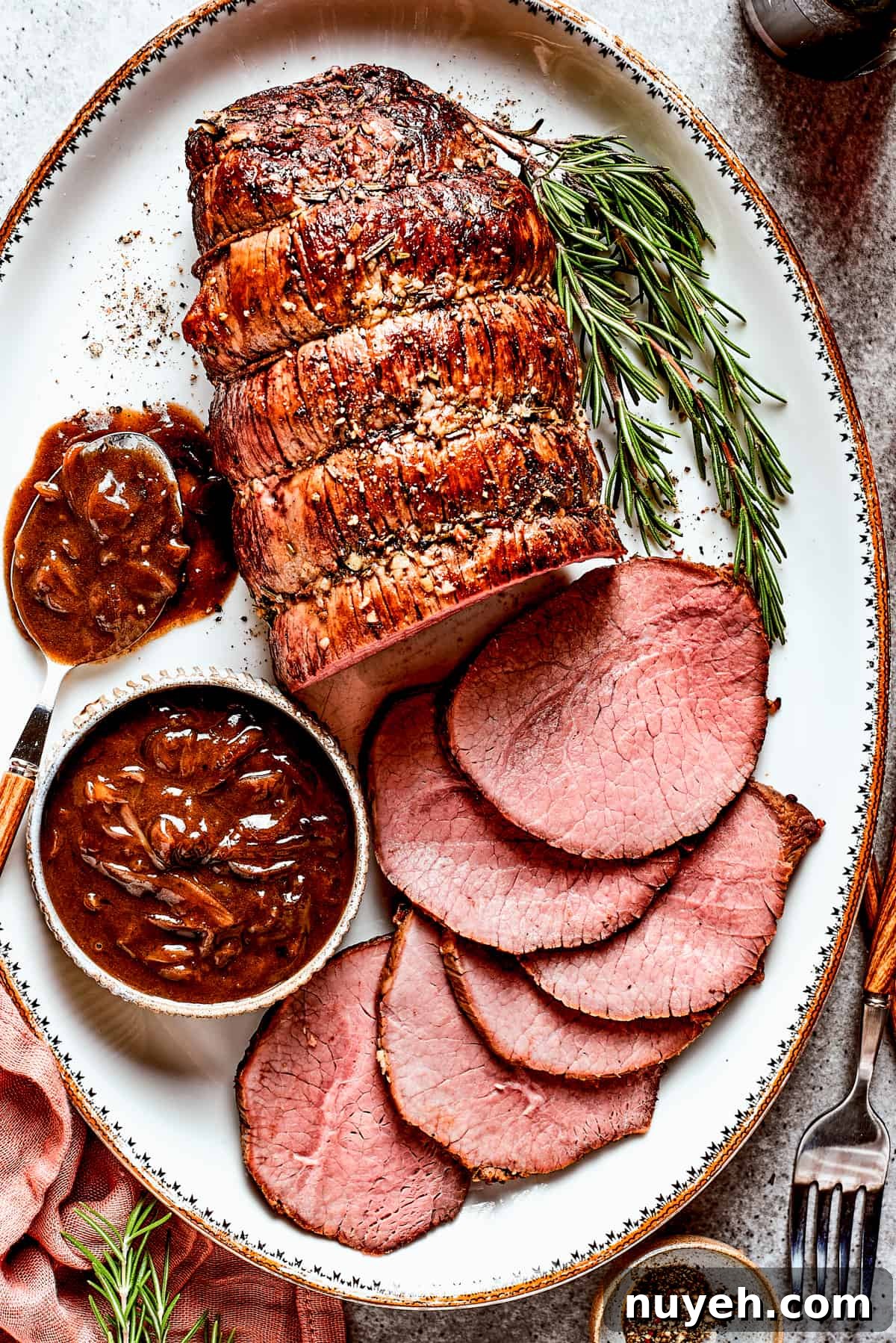Top view of a sliced beef roast with gravy.