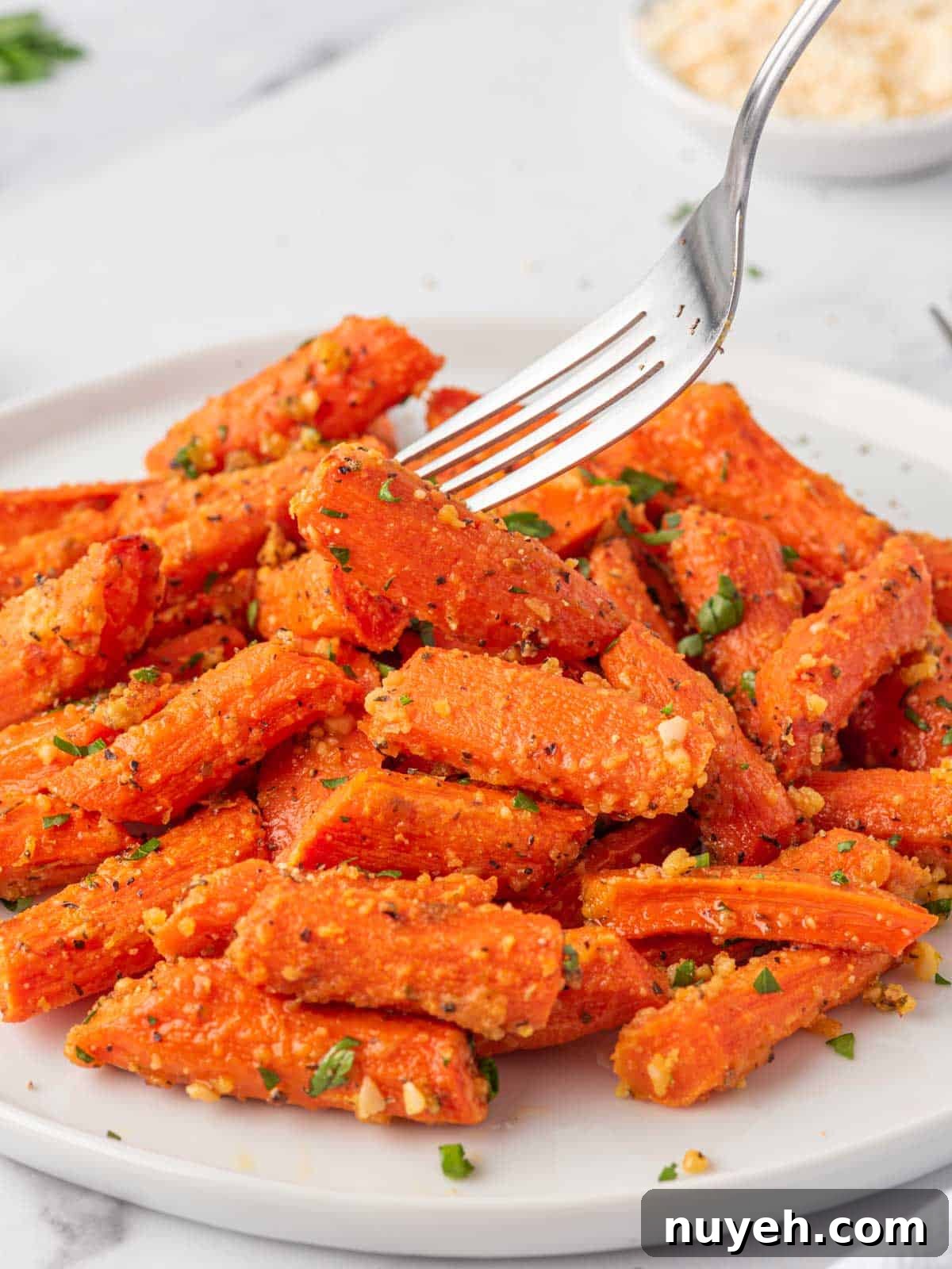 A fork picks up a oven roasted carrot.