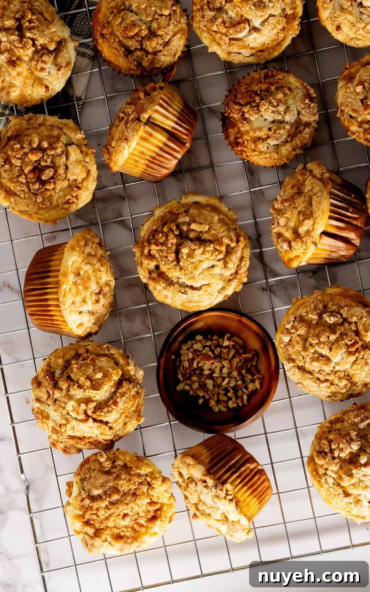 Pumpkin cheesecake muffins topped with brown sugar pecans.