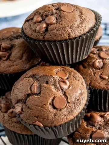 Bakery Style Chocolate Muffins stacked on wire rack.