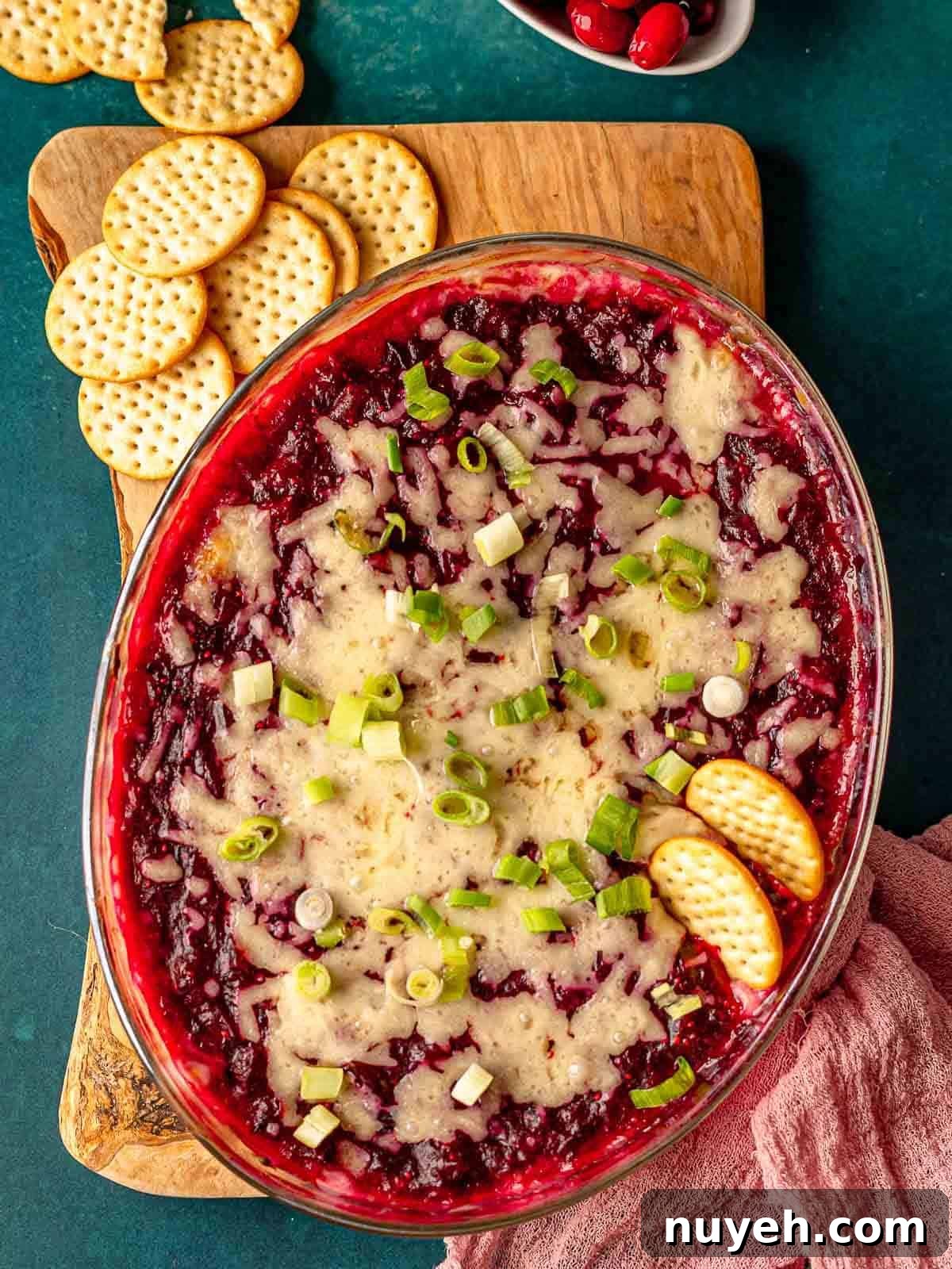Crackers stuck in cranberry jalapeño cream cheese dip.