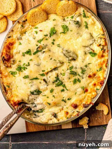 Crab spinach artichoke dip on a cutting board.