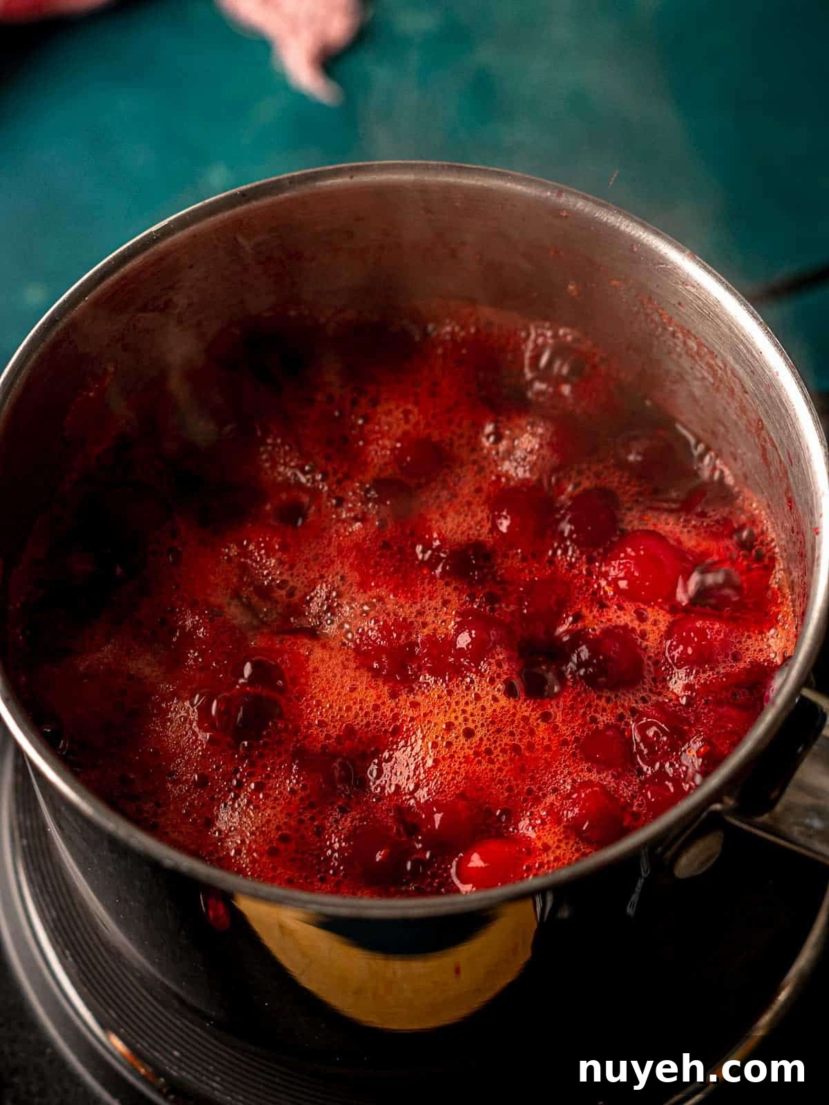 Cranberries simmering in a saucepan.