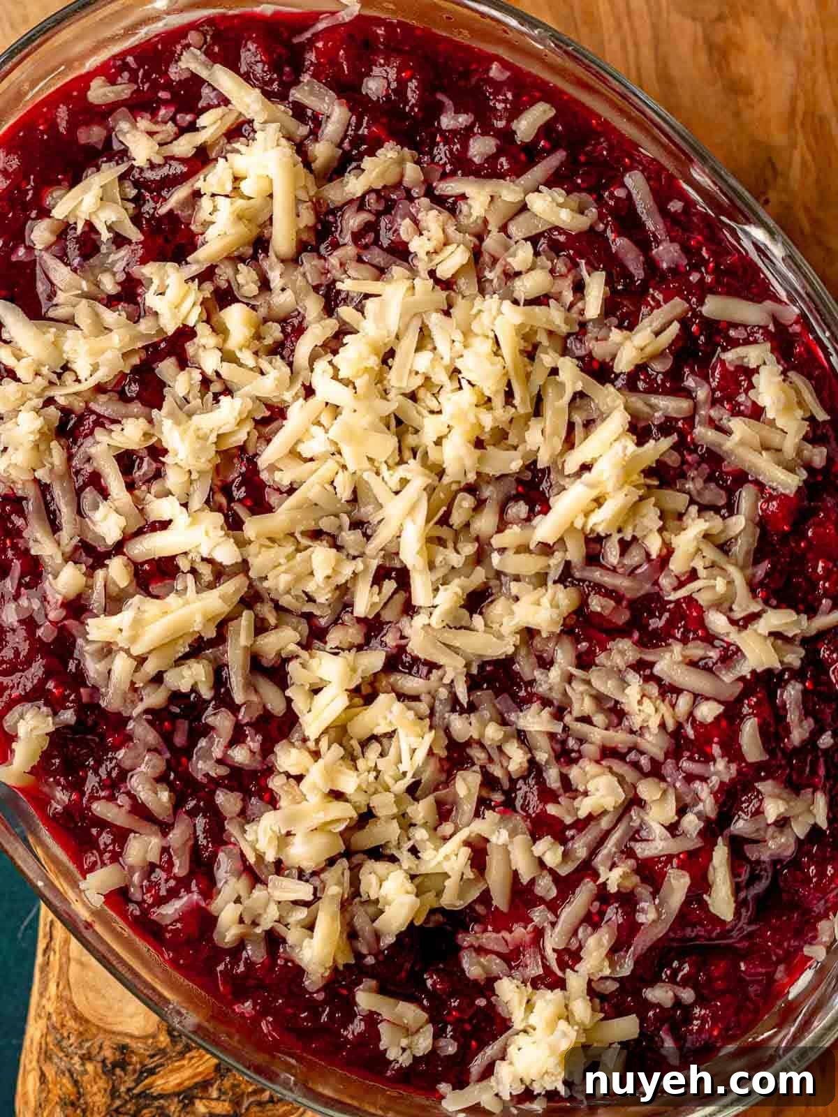 Shredded cheese on top of cranberry sauce.