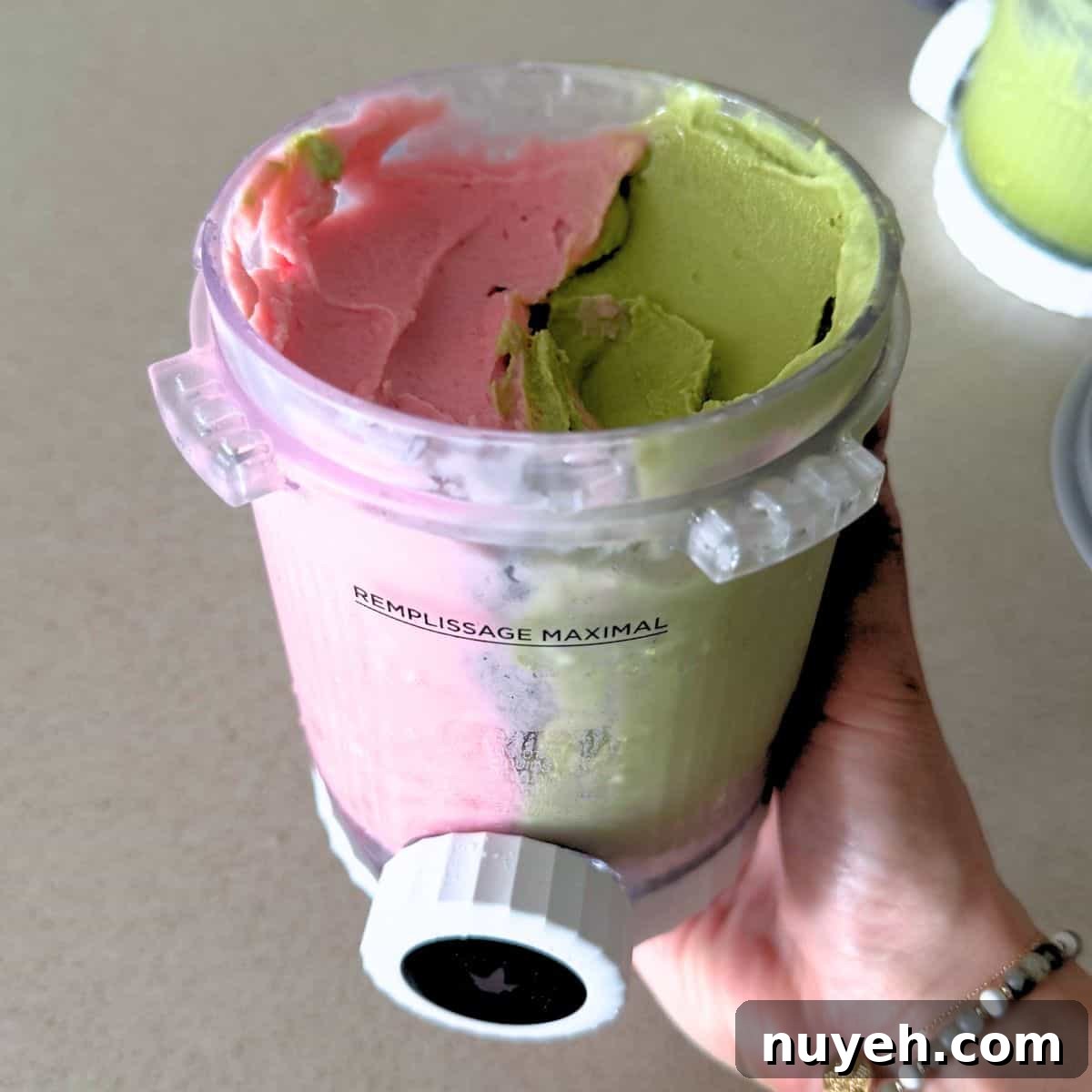 A Ninja Creami Swirl pint filled with half matcha and half strawberry ice cream.