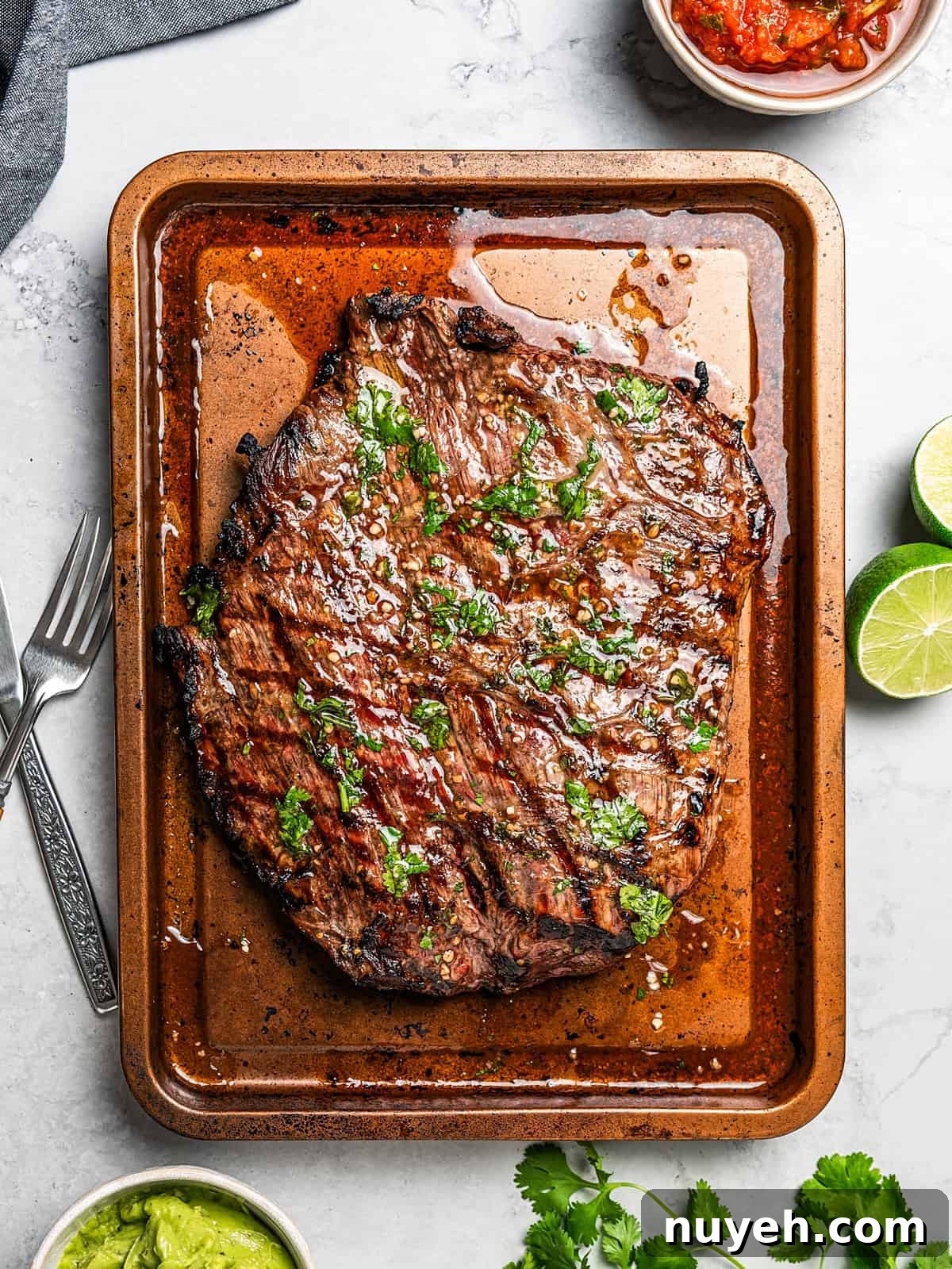 Cooked carne asada steak on a baking sheet.