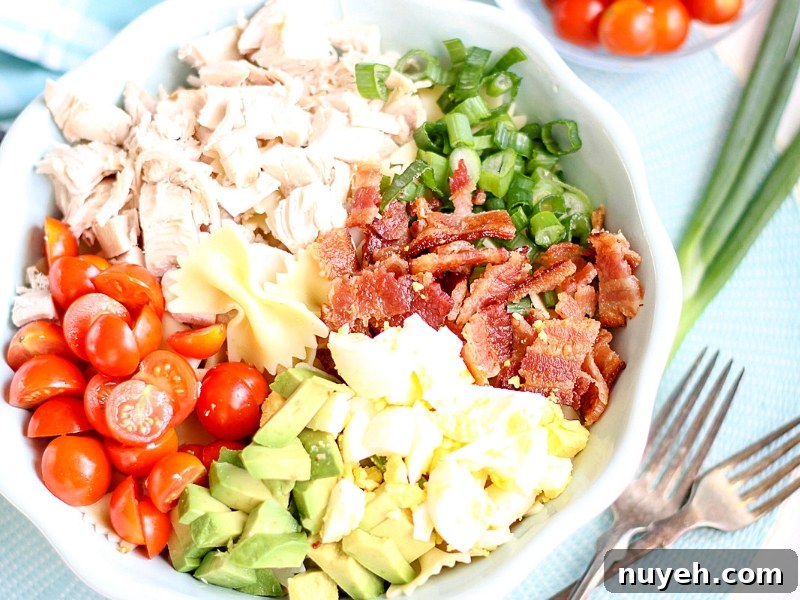 Ingredients for a Cobb Pasta Salad in a bowl.
