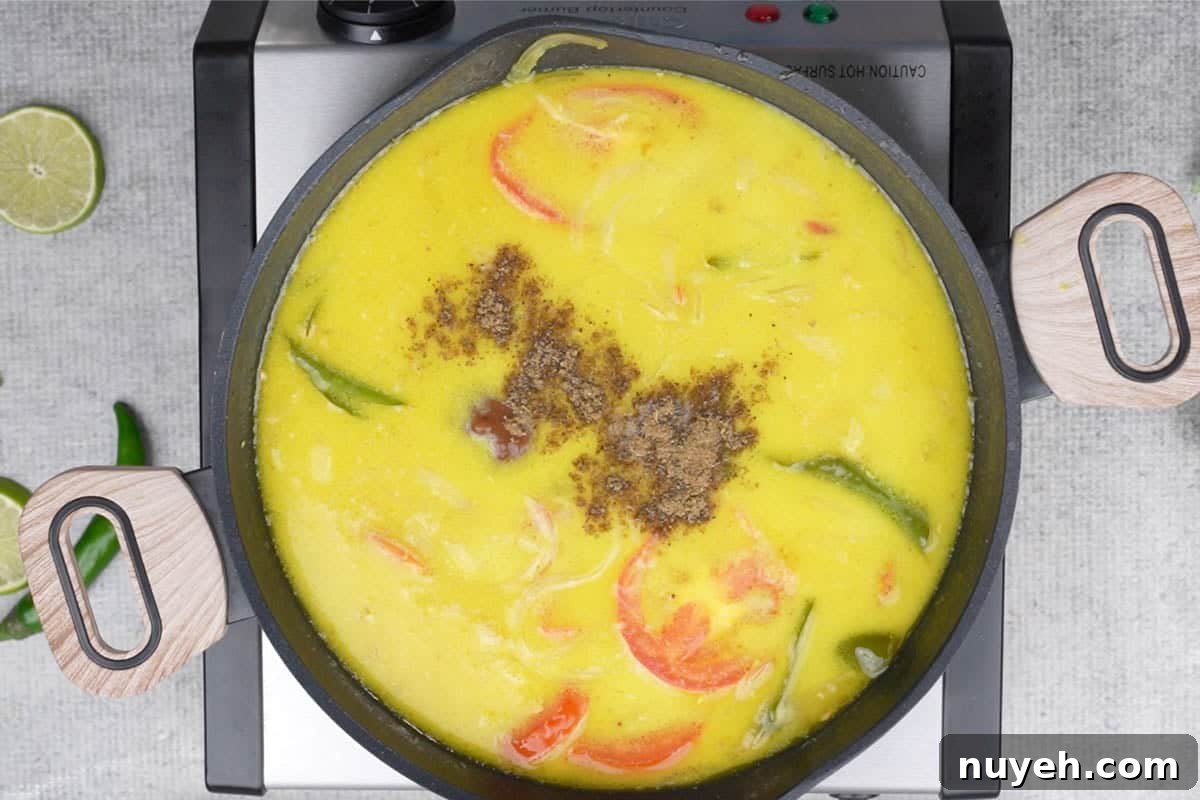 Thick coconut milk, tamarind and garam masala added to the pan.