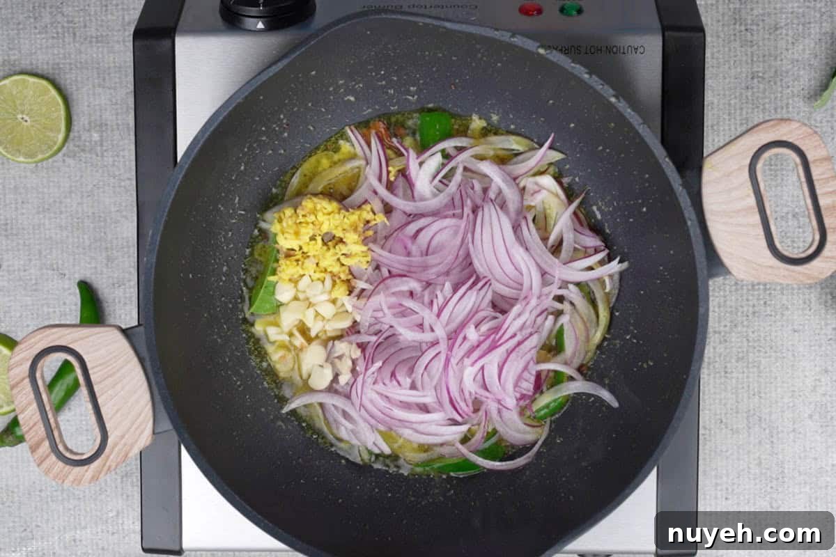 Onions, ginger and garlic added to the pan.