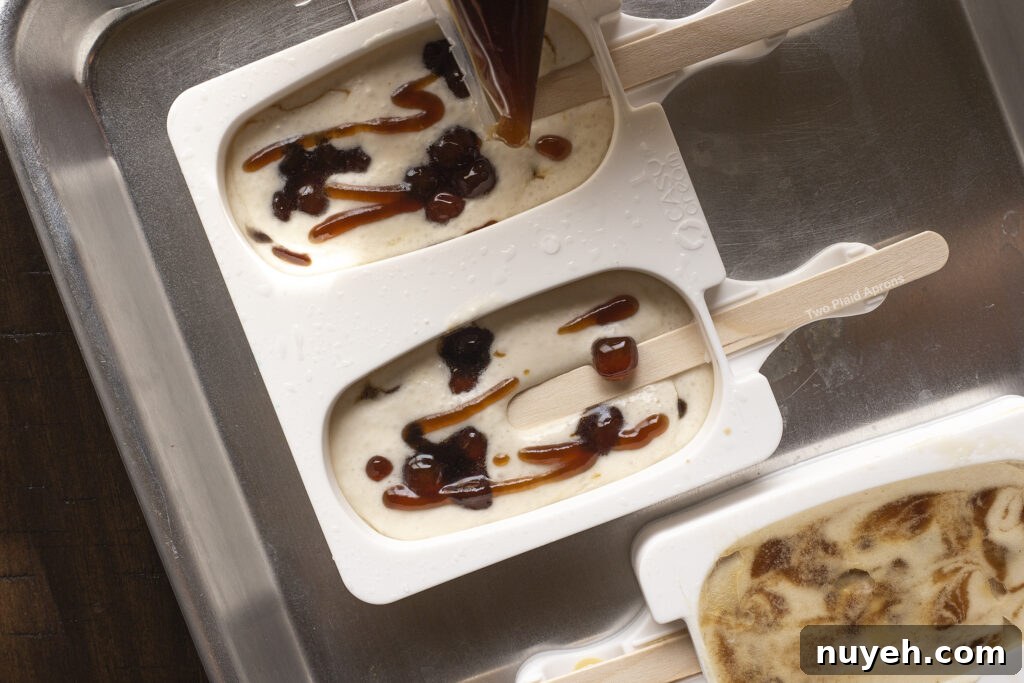 Piping in brown syrup into the ice cream mold.