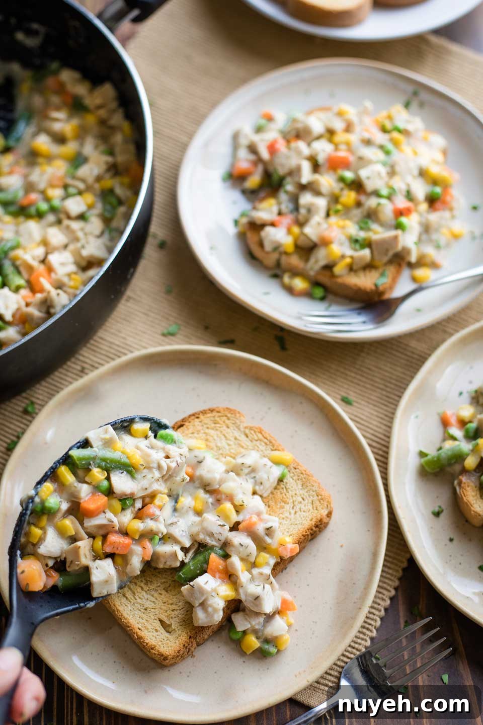 serving spoon spooning turkey pot pie filling over fresh toast