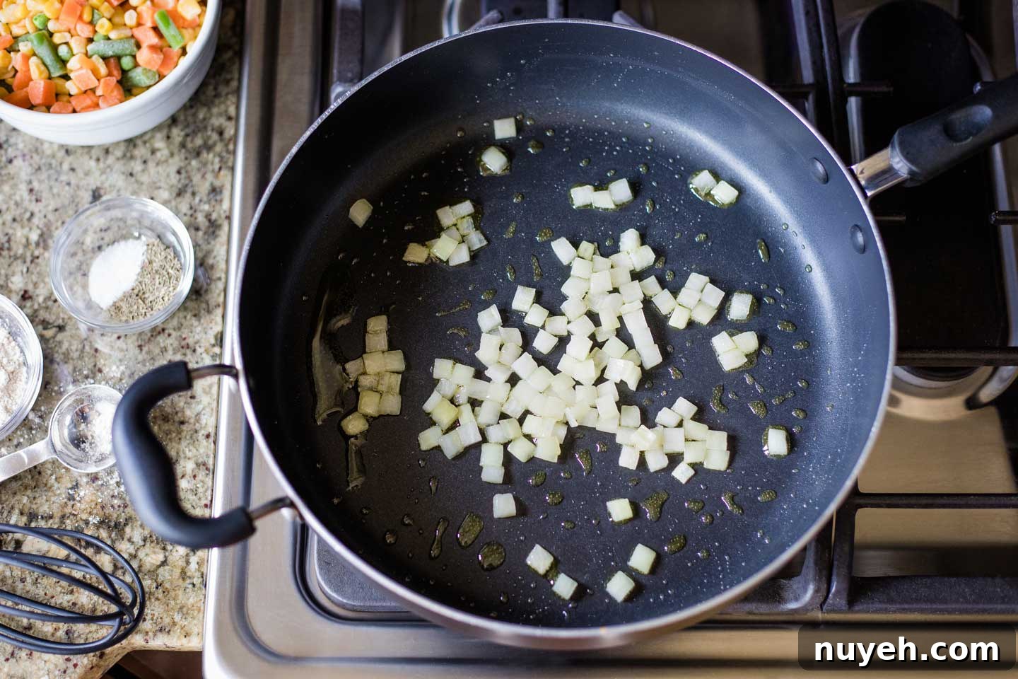 nonstick skillet with olive oil and chopped onion cooking