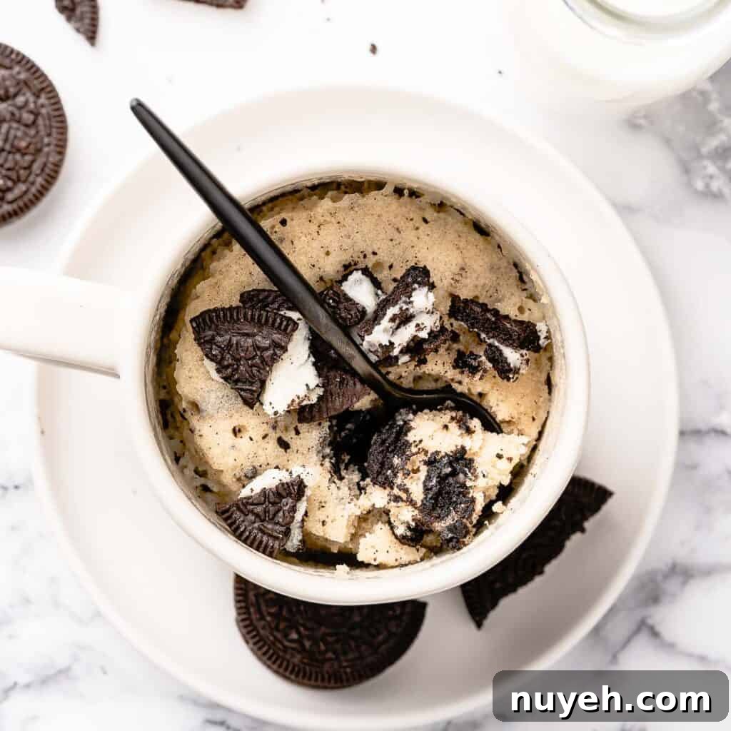 Oreo mug cake in white mug with black spoon