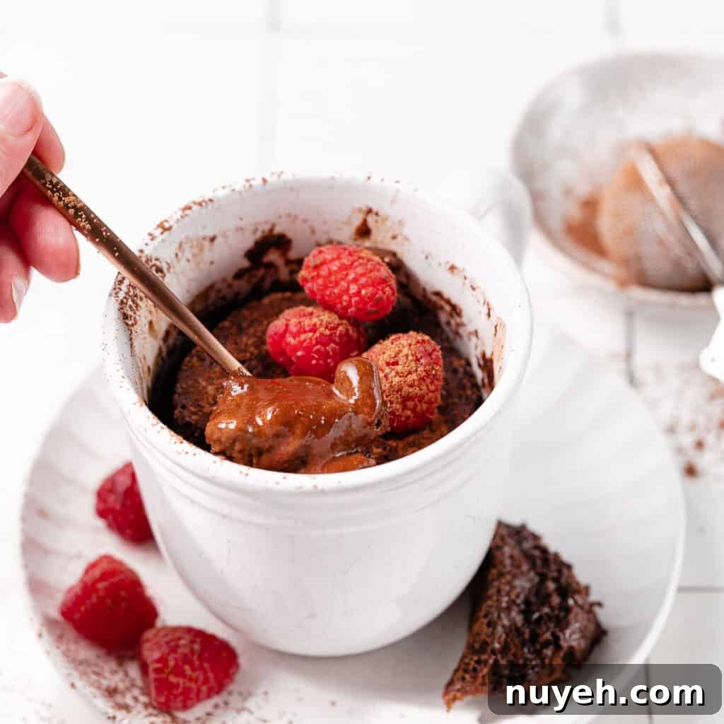 mocha mug cake with raspberries and spoon