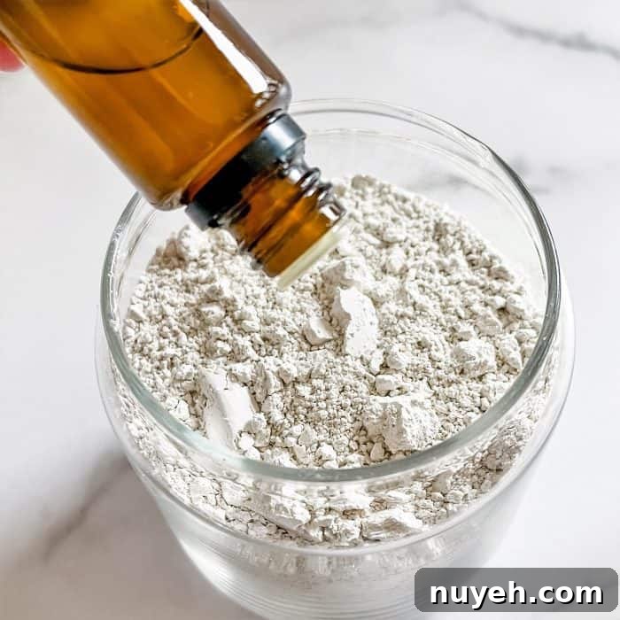adding essential oil to glass jar to make homemade deodorizer