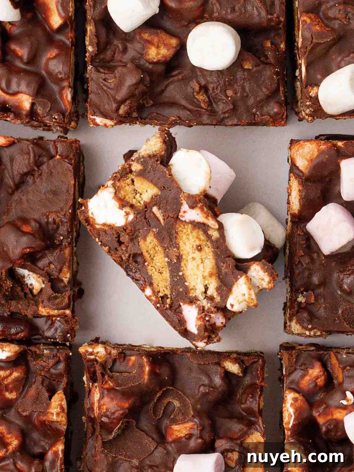 Squares of rocky road with one in the middle on its side, showing the inside.
