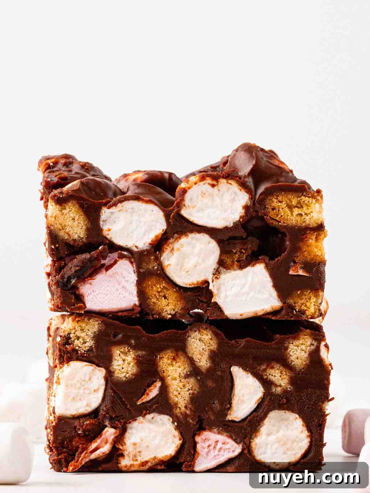 Two squares of rocky road from a side angle on top of each other.