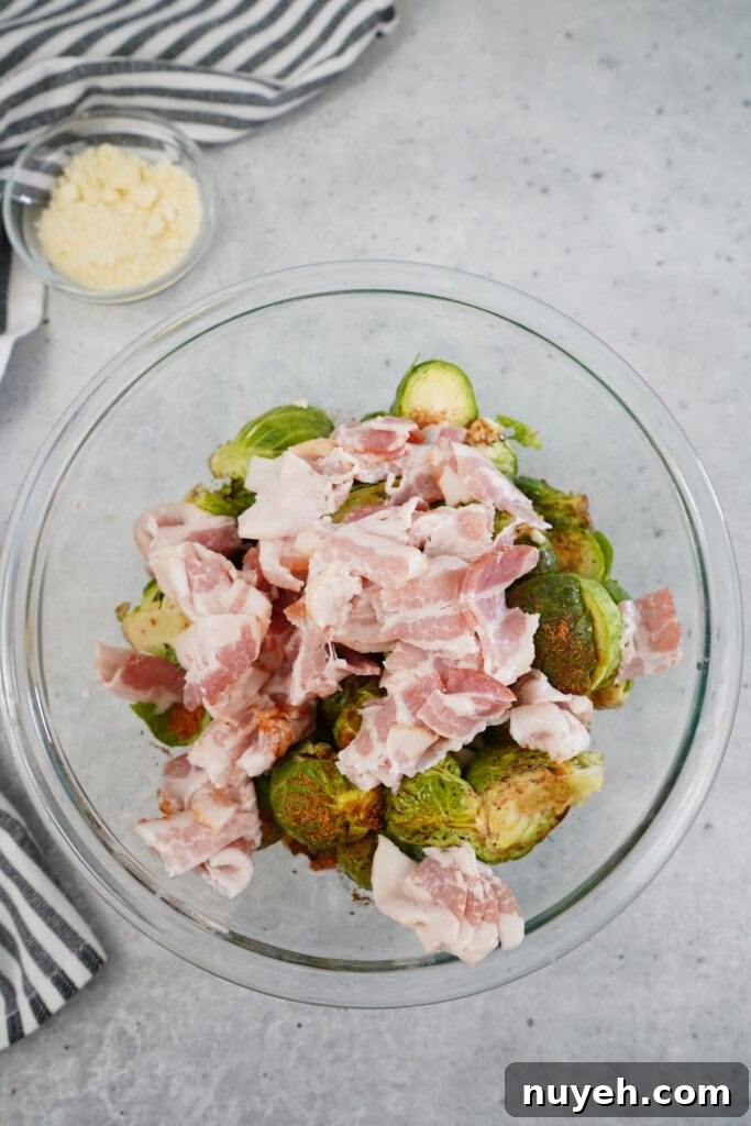 Seasoned Brussels sprouts with bacon on a baking sheet