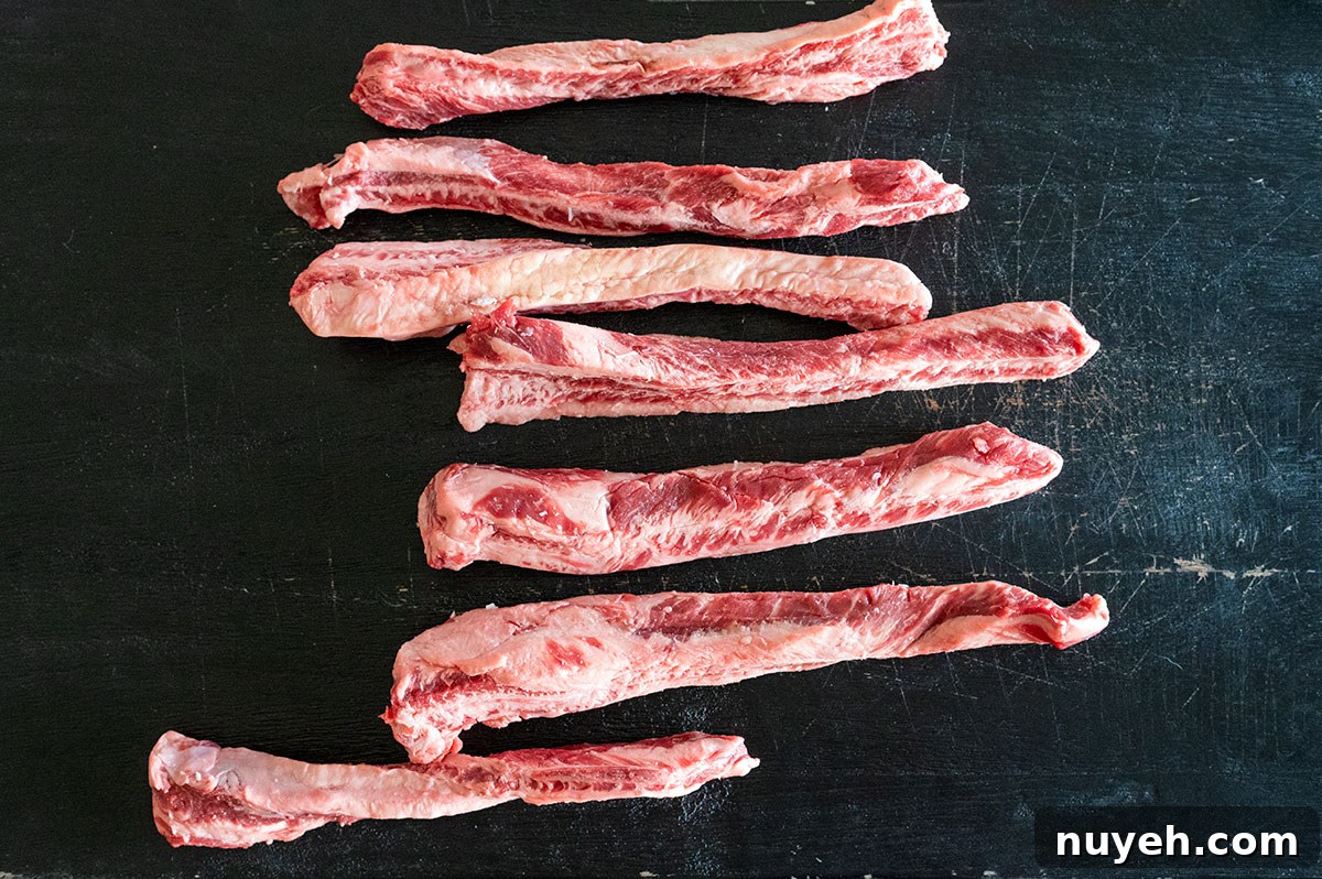 Raw beef fingers on a black board.