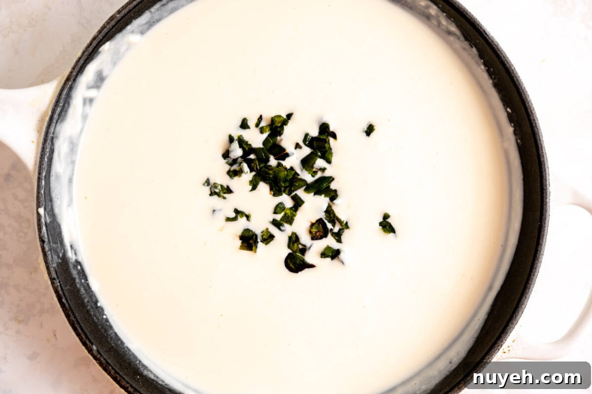 Skillet with white queso and roasted jalapeno added. 