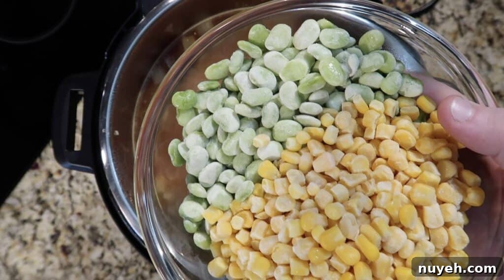 Adding frozen lima beans and corn to pot