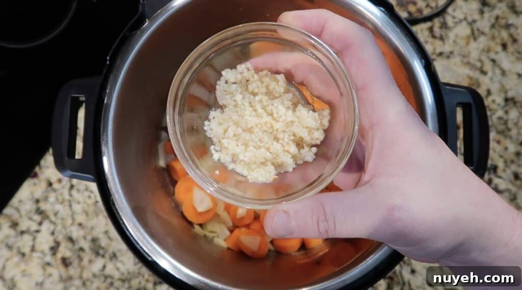 Adding garlic to pot.