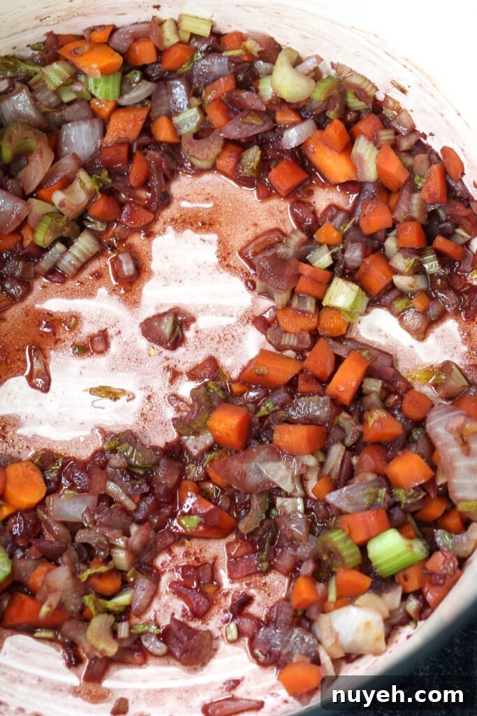 diced vegetables in a soup pot deglazed with red wine