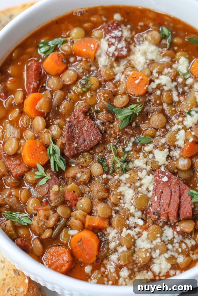 lentil soup with ham in a bowl with parmesan cheese and fresh thyme