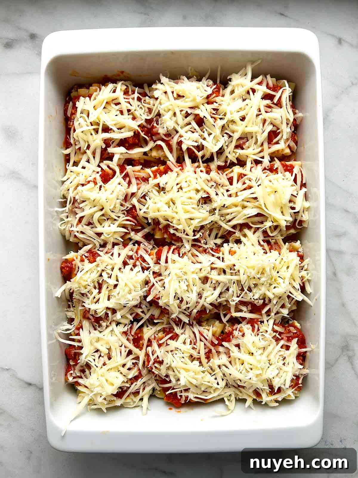 shredded mozzarella sprinkled on top of meat sauce.