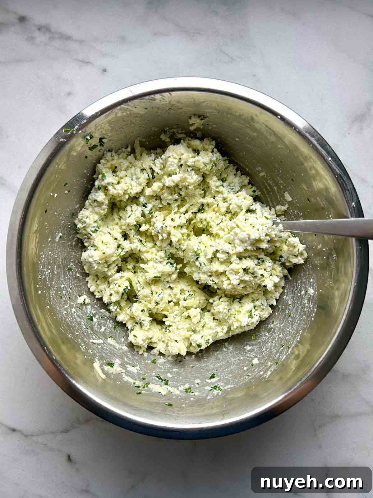 ricotta filling being mixed in metal bowl.