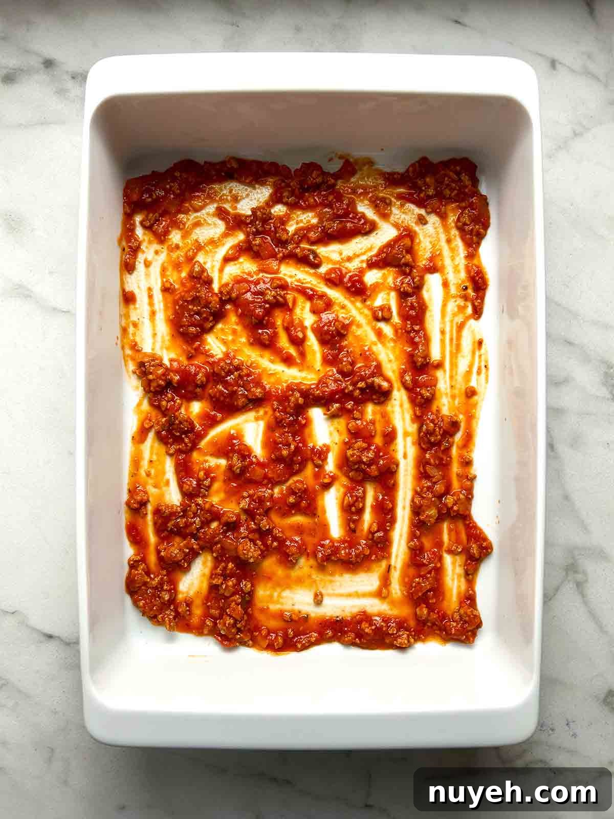 meat sauce spread in bottom of baking dish.