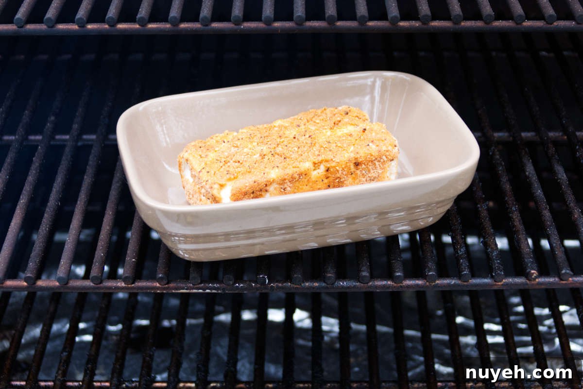 block of cream cheese in baking dish on Traeger grates