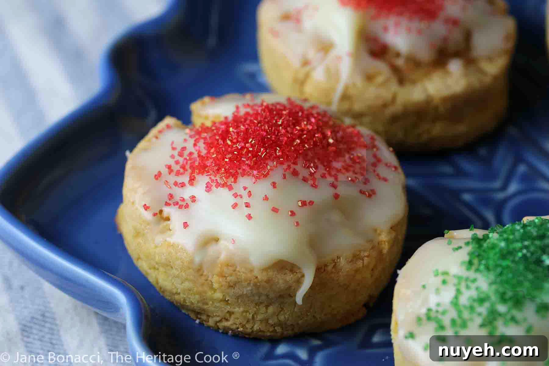 Close up of a white chocolate scone with red sprinkled sugar on top.