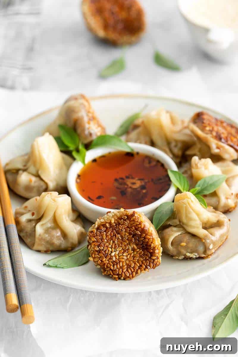 Vegetarian dumplings and garlic chili oil on a white plate with chopsticks on the side.