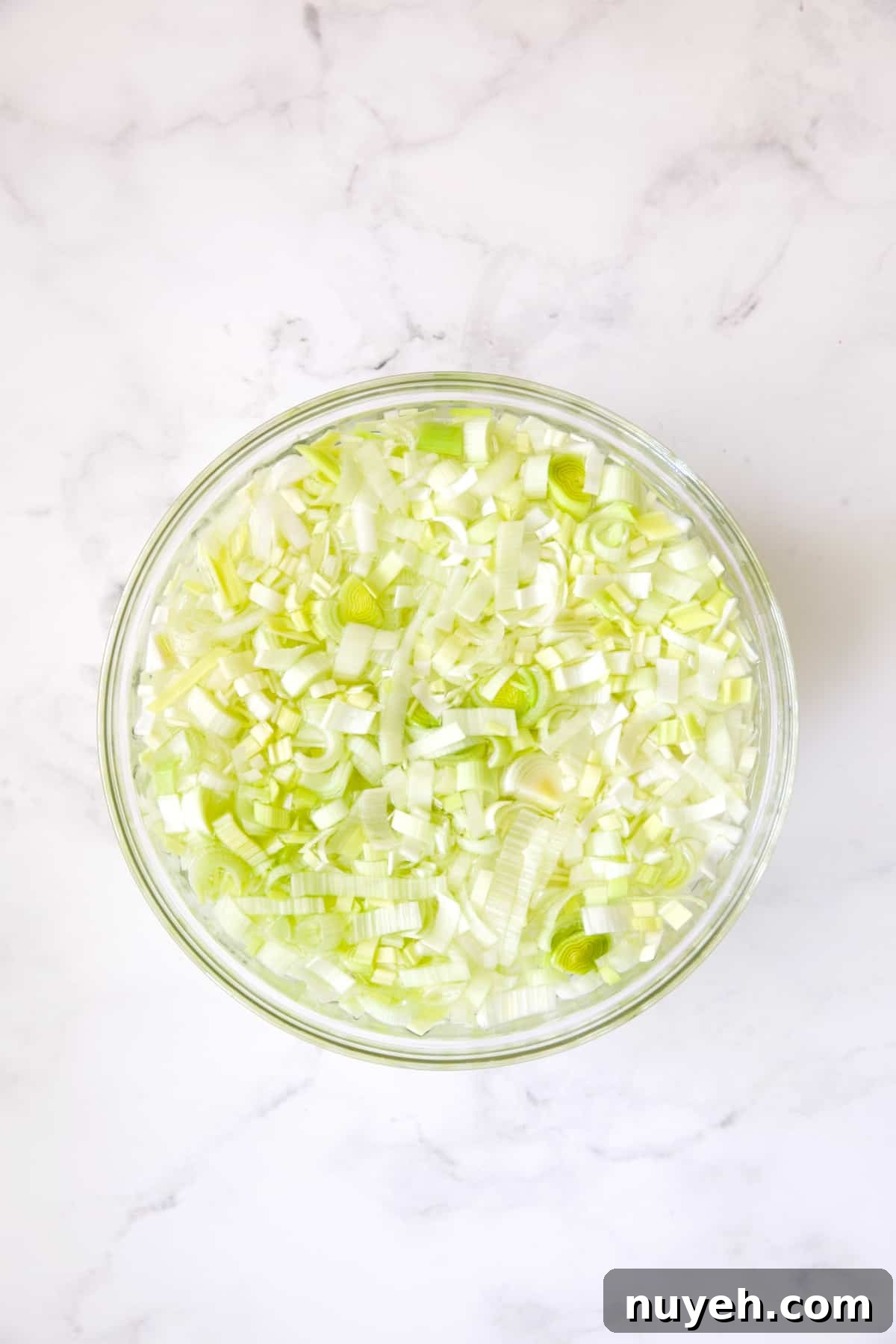 Sausage, Fennel and Leek Stuffing Recipe 5 Leeks in water in glass bowl.