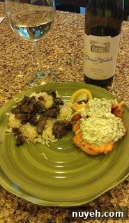 A plate with salmon covered in dill pepperoncini cream sauce with mushroom rice on a counter.