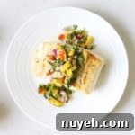 halibut plated with mango salsa and coconut rice on a white surface