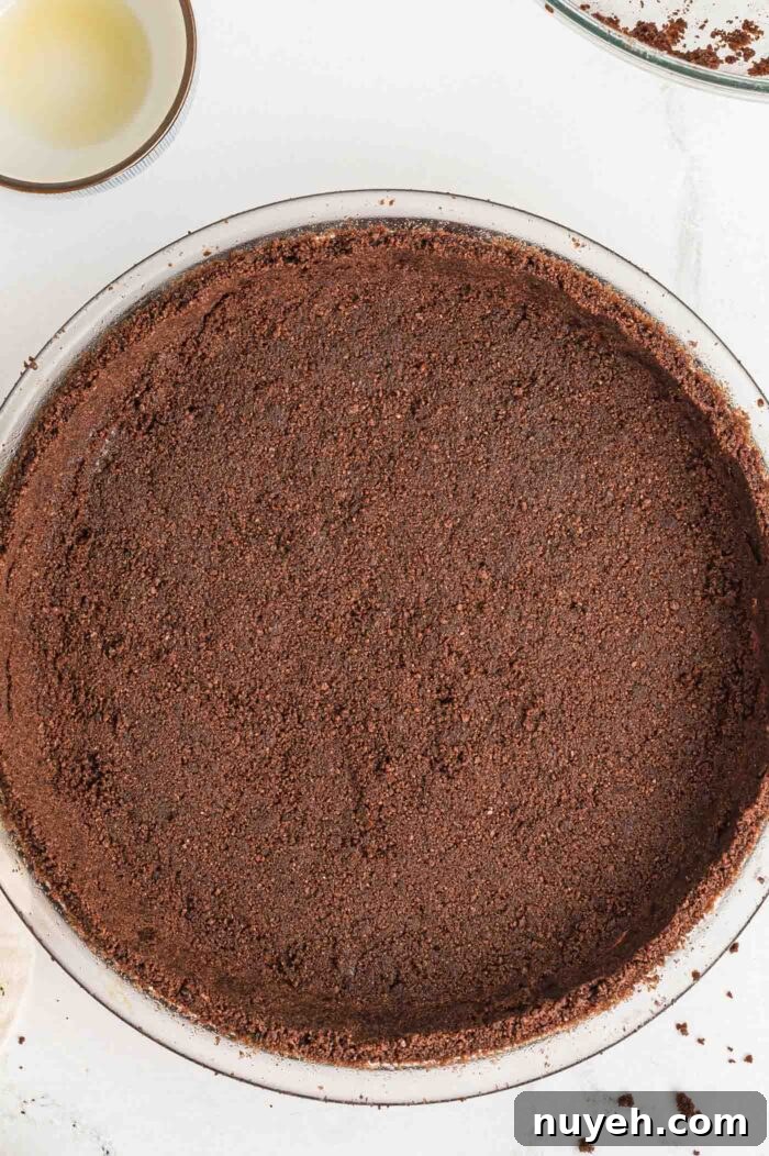 A chocolate graham cracker pie crust firmly pressed into a round 9-inch glass pie dish.