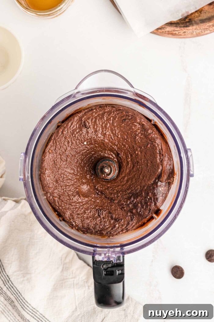 A creamy chocolate pie filling mixture in a food processor container.