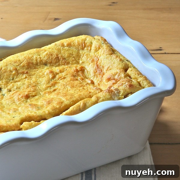 A white baking dish of gluten free, pumpkin pie spoon bread.