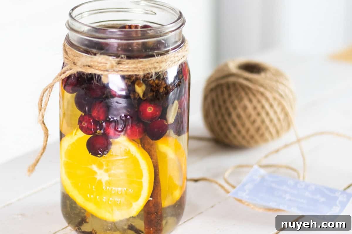 DIY Stovetop Potpourri with Essential Oils 6 Stovetop potpourri in a glass jar with sliced oranges and fresh cranberries.