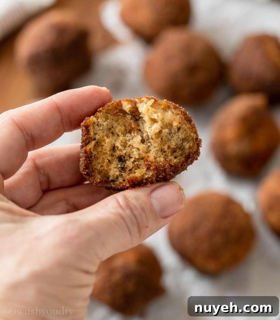 moist and tender banana muffin with bite taken out, in left hand.