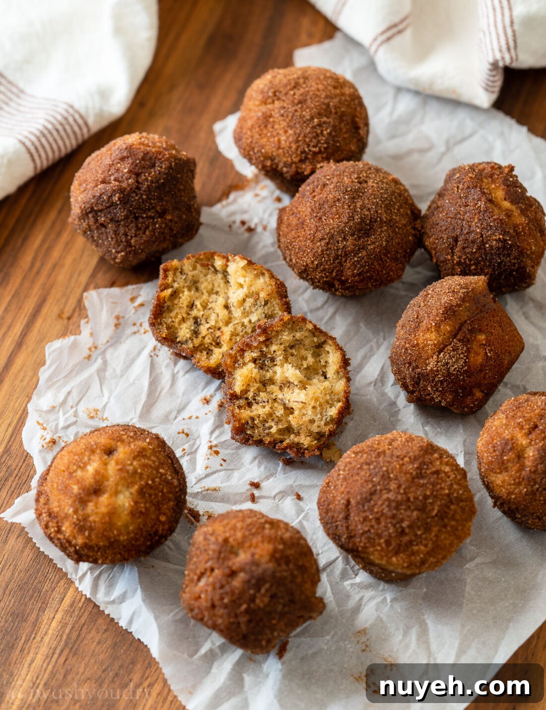 mini banana muffins on countertop, one open to reveal the inside.