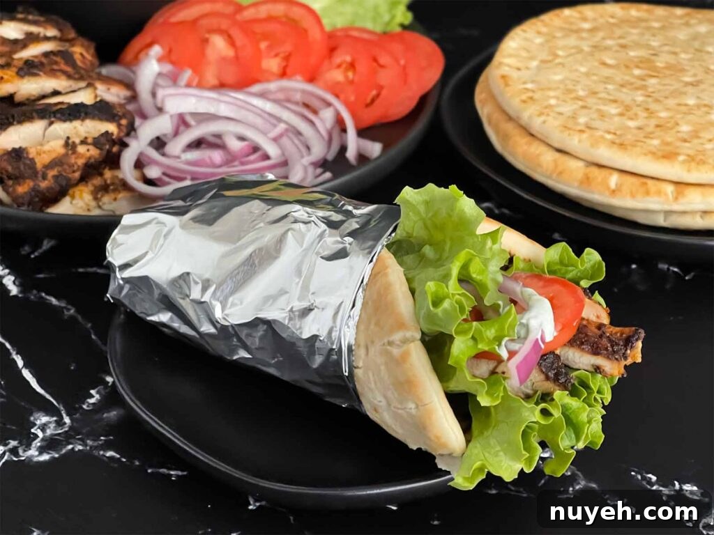 Grilled Chicken Shawarma Recipe with Garlic Yogurt Sauce 2 Grilled chicken shawarma on a dark plate.