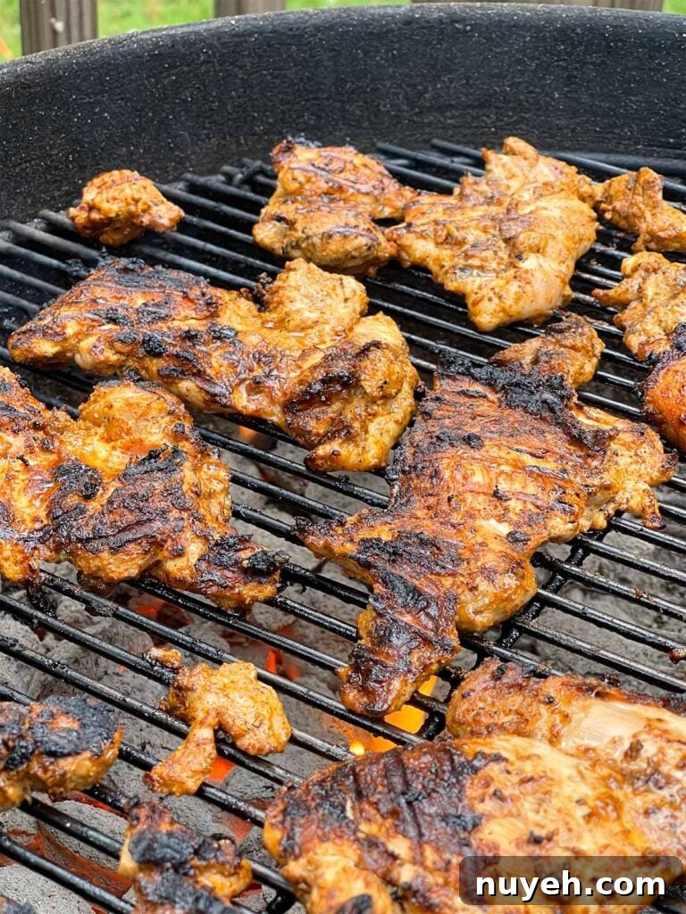Grilled Chicken Shawarma Recipe with Garlic Yogurt Sauce 5 Chicken thighs cooking on a kettle grill.