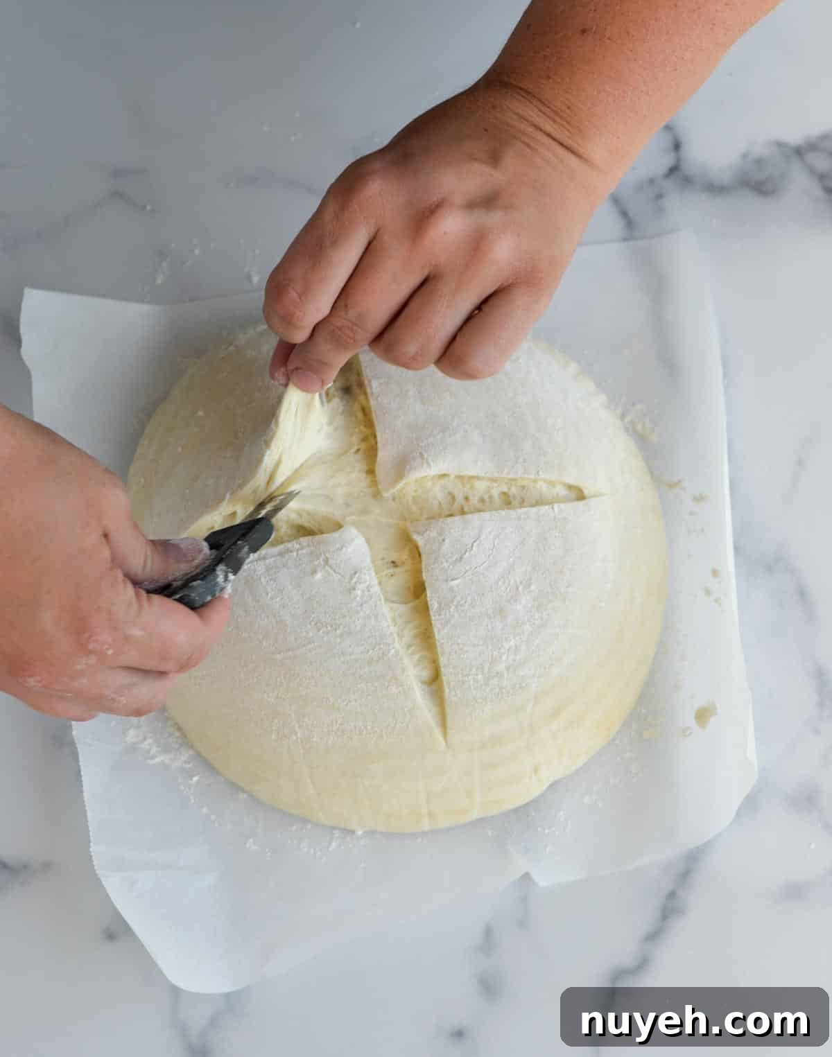 Dough being scored on a countertop.