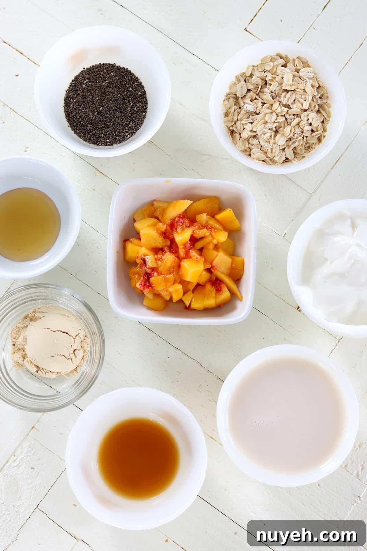 Ingredients needed for making overnight peach oats on a white wooden board.