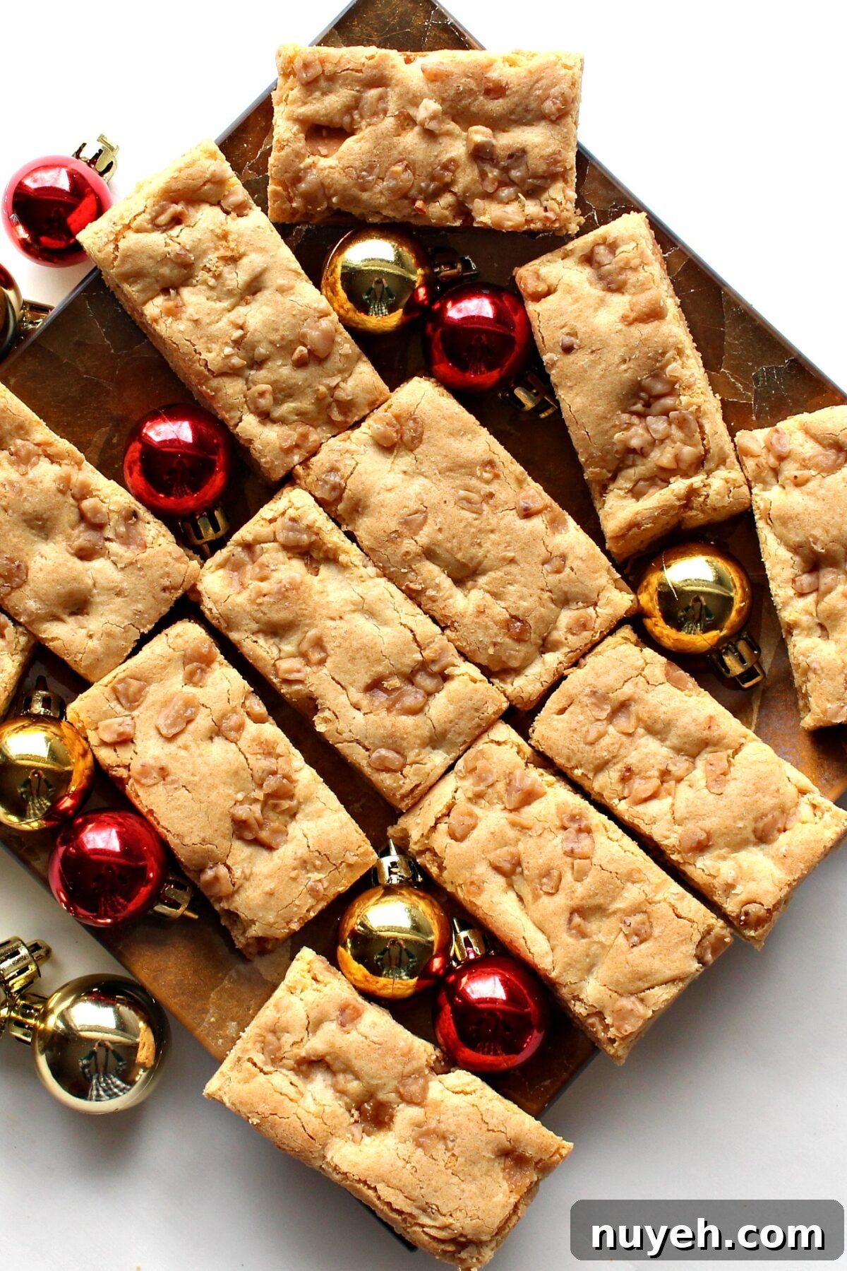 Blondie Bars  with butterscotch chips on a platter with Christmas ornament balls.