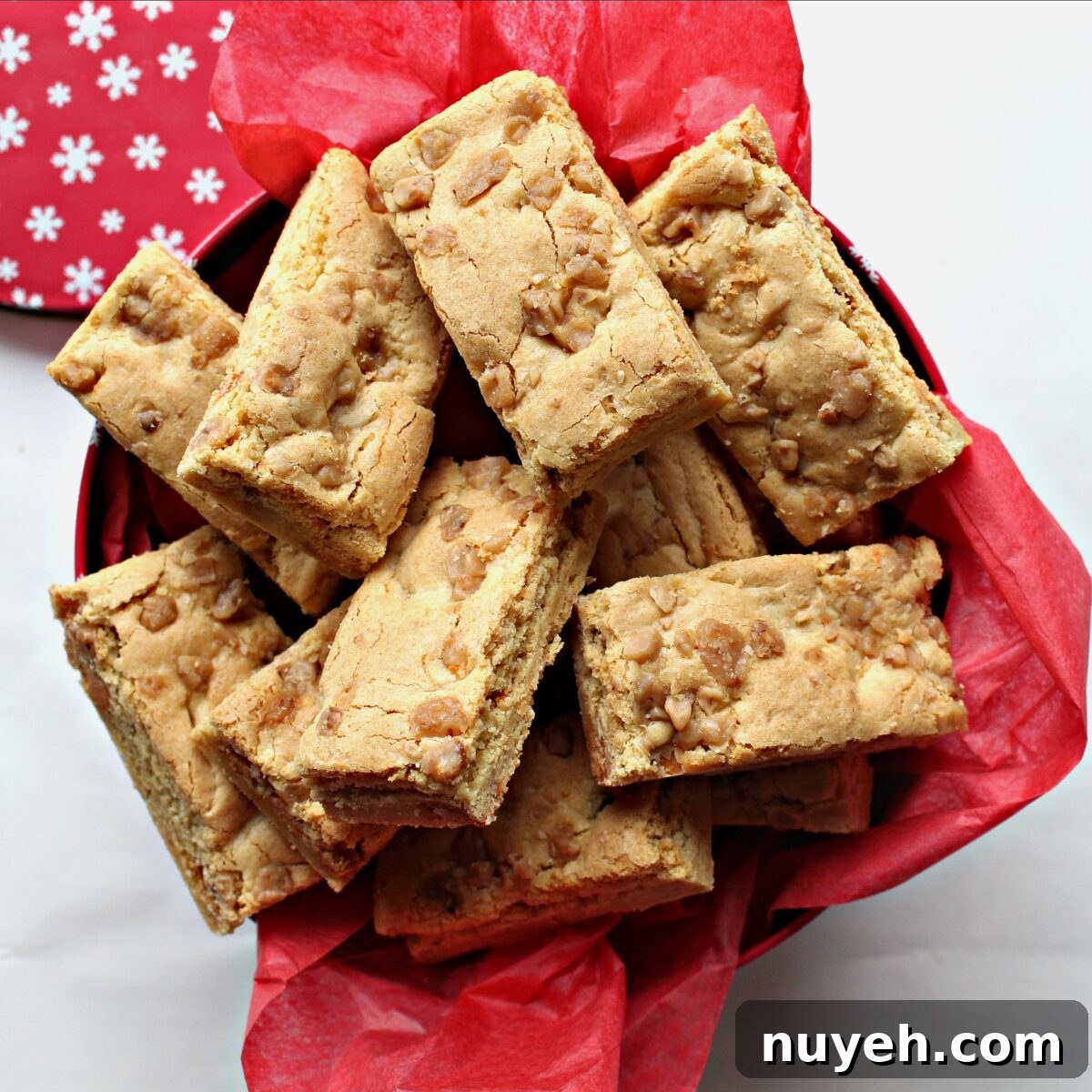 Butterscotch Blondie Bars  in a gift tin lined with red tissue paper.